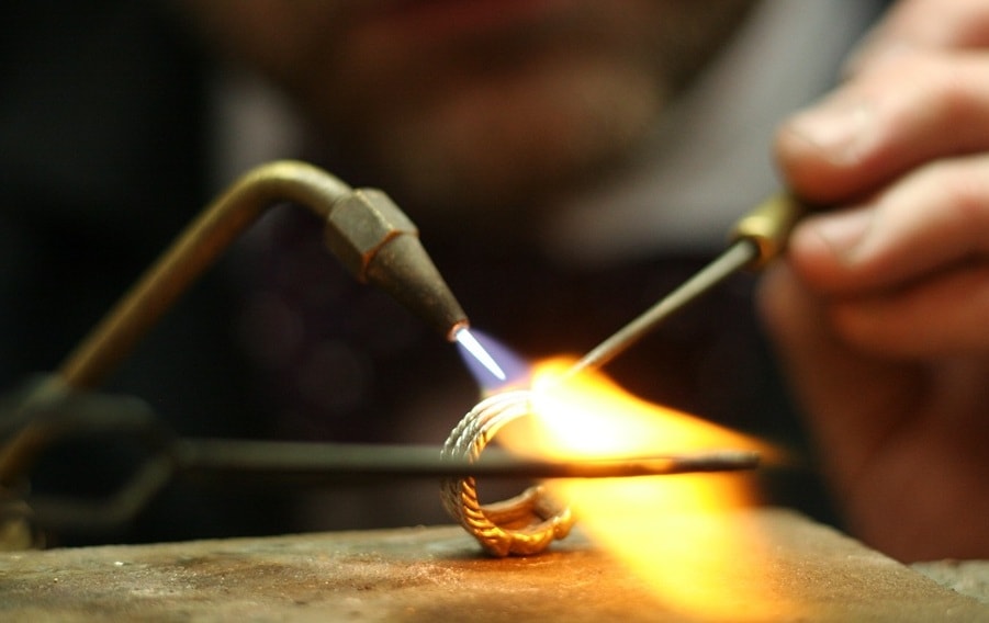 Jeweler soldering a ring with torch